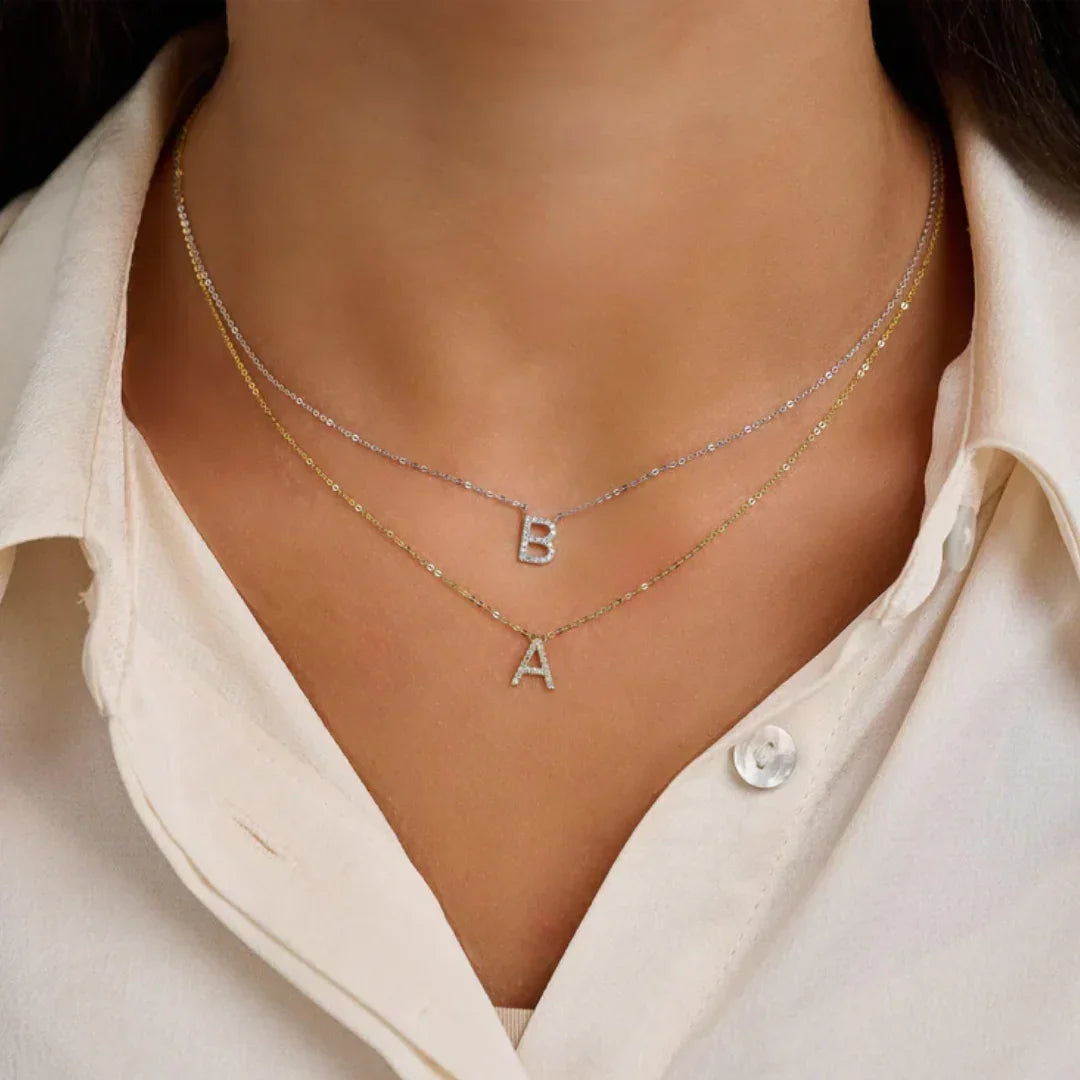 'B' and 'A' Letter Initial Necklace on a person wearing a white shirt.