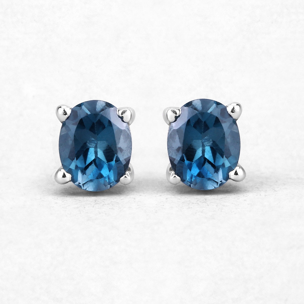 0.80 Ct Oval Blue London Blue Topaz Sterling Silver Rhodium-Plated 4 Prong Stud Earrings