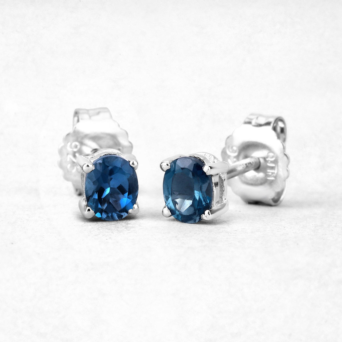 0.80 Ct Oval Blue London Blue Topaz Sterling Silver Rhodium-Plated 4 Prong Stud Earrings