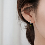model shocasing  Evil Eye Peridot Earrings with Natural Peridot Green Peridot Dangling Rhodium Plated Silver Earrings